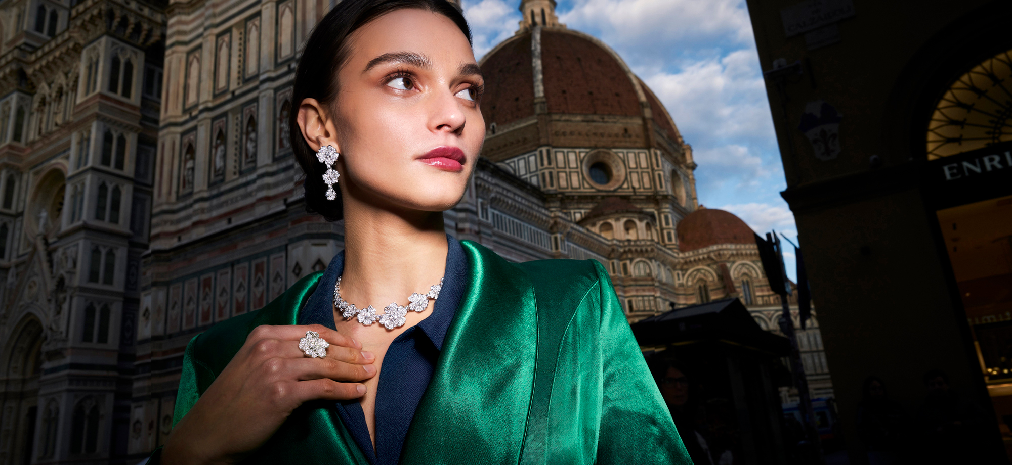 Modella con giacca verde e gioielli floreali Leo Pizzo davanti al Duomo di Firenze